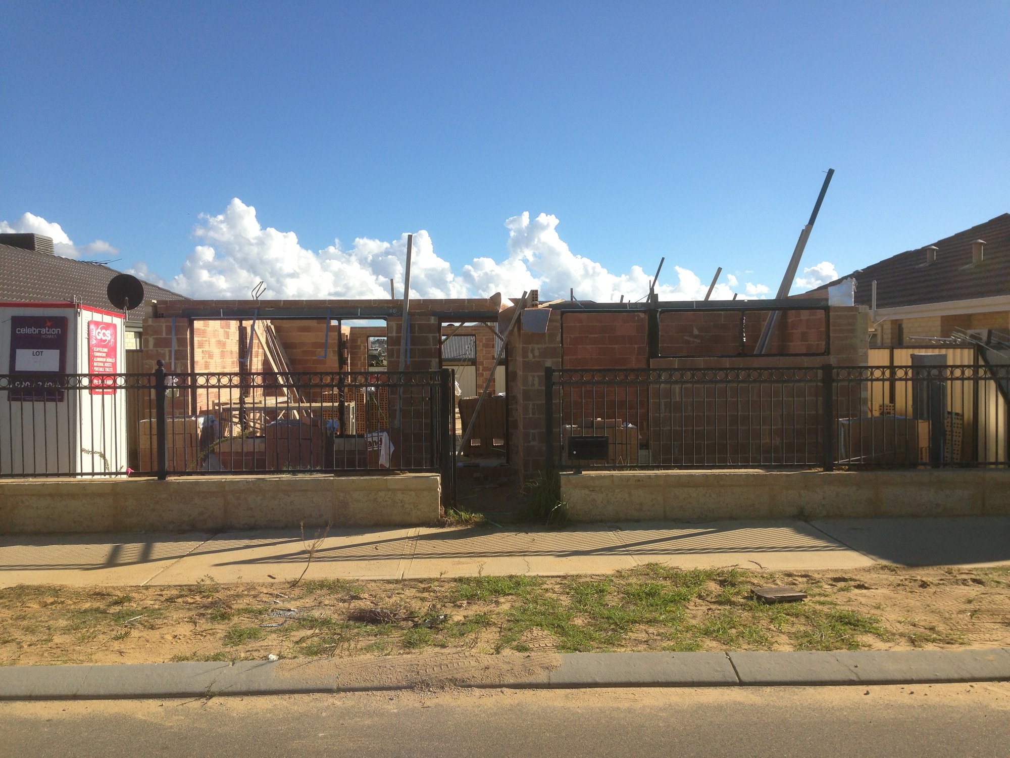 New home under construction at brick and roof-frame stage