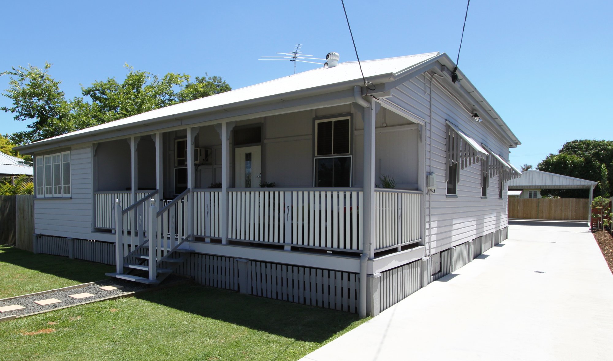 Weatherboard Queenslander-style home exterior with a wraparound veranda
