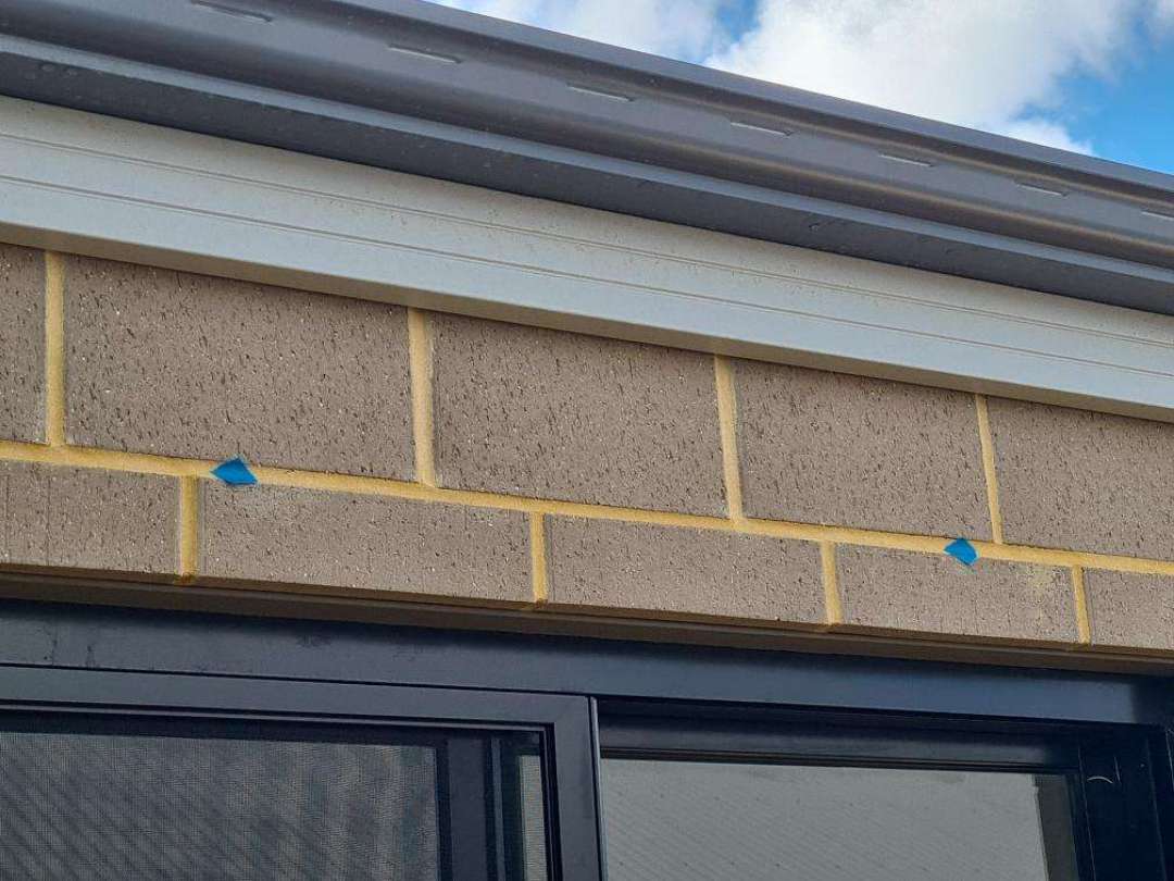 Missing Weep Holes Above Windows — real moisture defect photographed in a SURE Building Inspections report