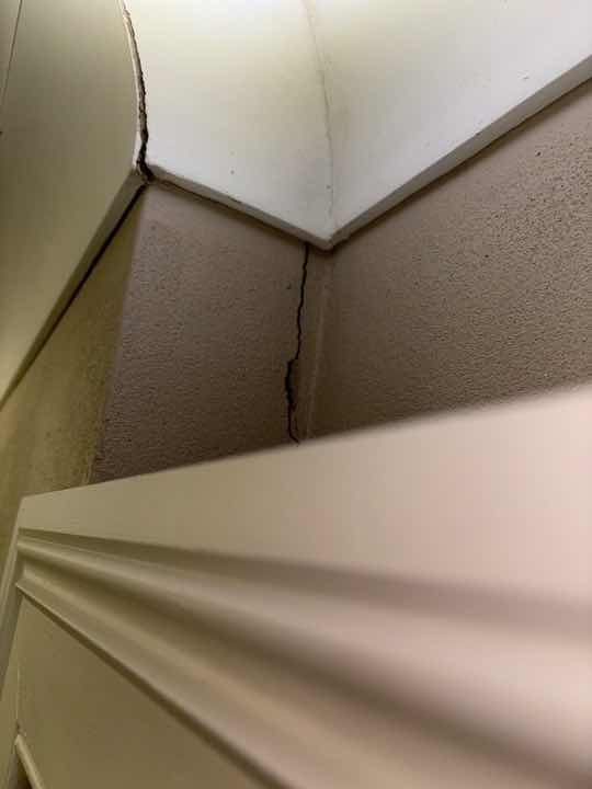 Wall Cracking due to Settlement — real structural defect photographed in a SURE Building Inspections report