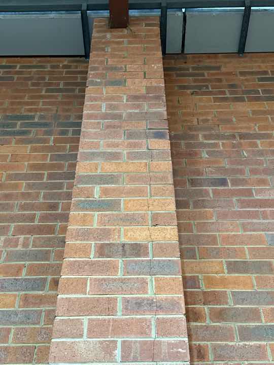 Warehouse Area Termite Damage to Skirting/Wall — real termite defect photographed in a SURE Building Inspections report