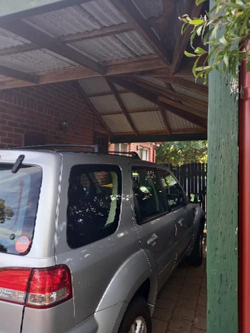 Severely Rusted Carport Post Stirrup — real structural defect photographed in a SURE Building Inspections report