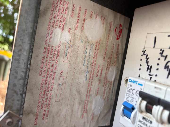 Illegible Termite Treatment Notice — real termite defect photographed in a SURE Building Inspections report